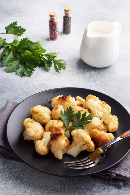 Coliflor frita en una placa negra