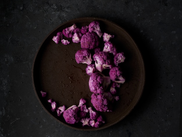 Coliflor morada en un plato oscuro