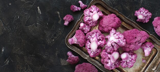 Coliflor púrpura fresca cruda sobre una tabla de madera cerrar