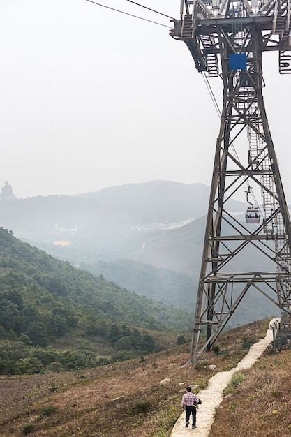 Colina de Ngong Ping e o teleférico na ilha de Lantau, em Hong Kong. Homem no fundo dele