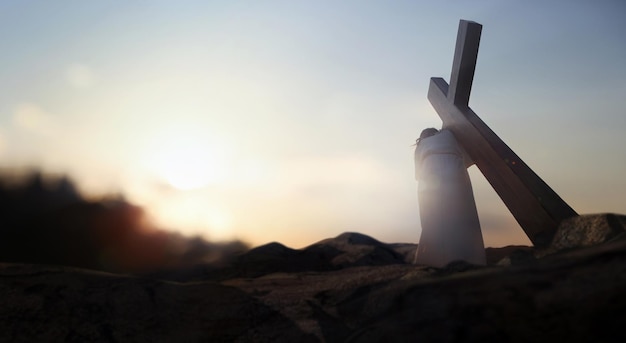 Foto colina do gólgota céu vermelho e luz brilhante jesus carregando a cruz durante a semana da paixão simbolizando p