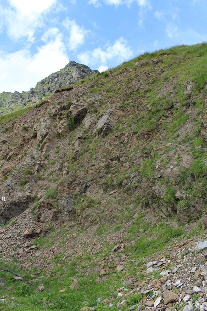 Una colina rocosa con hierba y rocas.