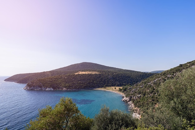 Colinas baixas de forma arredondada com pequenas árvores e arbustos descem para o mar, sithonia, chalkidiki, grécia