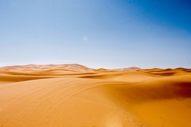 Foto colinas de areia em uma área deserta com vestígios deixados pelo vento