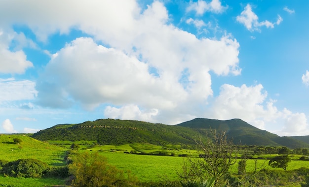 Colinas verdes bajo un cielo azul con nubes en Cerdeña Italia