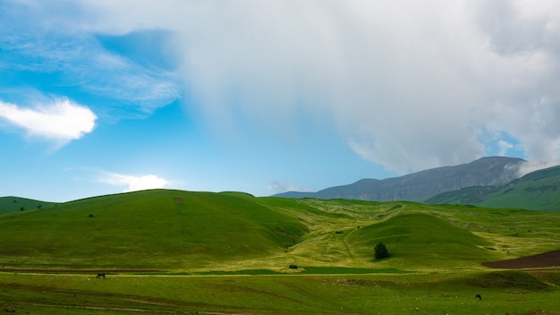 Colinas verdes e lindo céu azul com nuvens