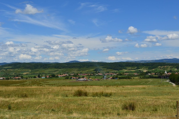 Colinas verdes em uma paisagem de montanhas durante a paisagem pitoresca do pôr do sol