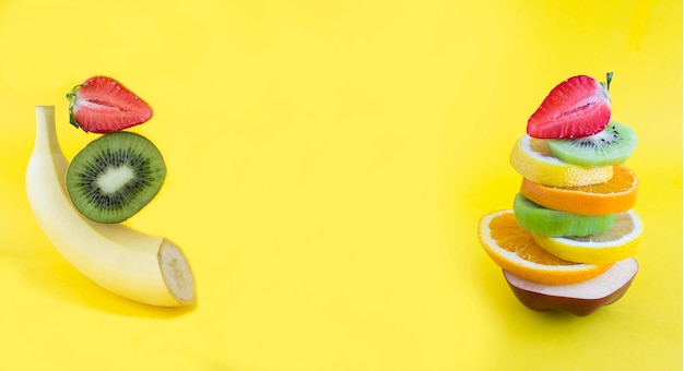 Collage Pyramide aus Obst und Beeren im Gleichgewicht auf gelbem Hintergrund Kopierbereich Nahaufnahme