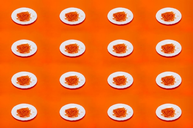 Collage con zanahorias en rodajas finas sobre un plato blanco sobre un fondo naranja