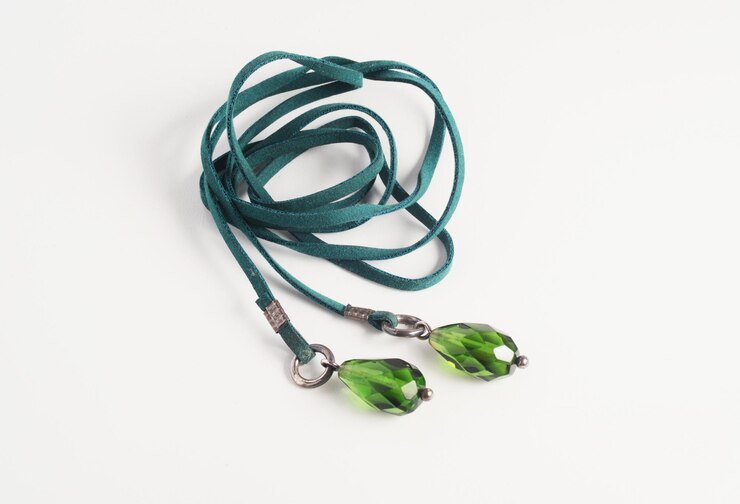 un collar de lariat hecho de correa de cuero verde y cristales verdes en forma de gota de agua
