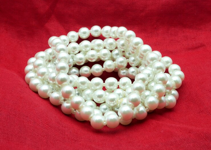 Foto collar de perlas sobre fondo rojo