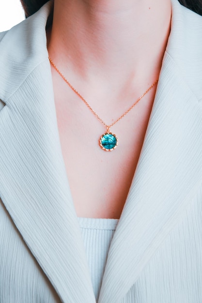 un collar con una piedra azul y una piedra verde.