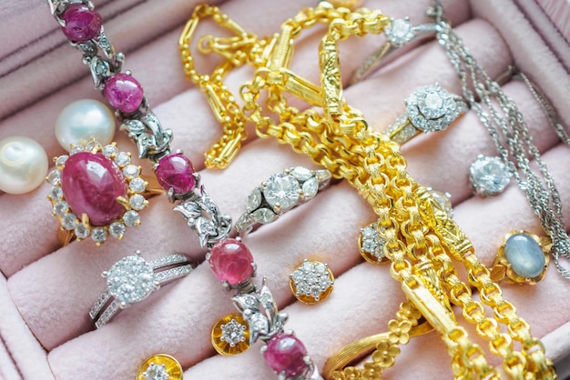 Collares de anillo de zafiro con piedras preciosas de diamantes de oro y plata y pendientes de perlas en un joyero de lujo
