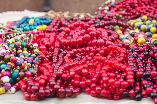 Collares multicolores de madera étnica en las decoraciones tradicionales del mercado