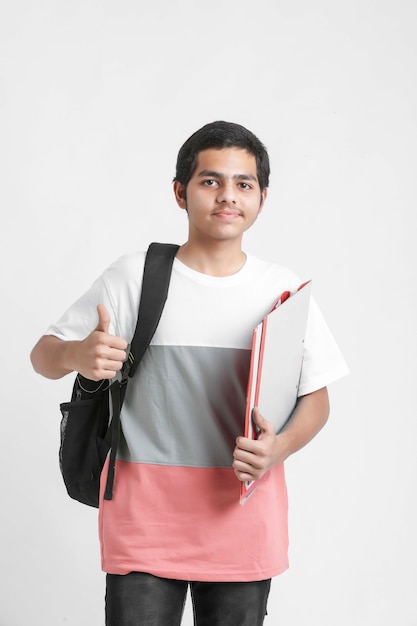 College Boy sosteniendo con archivos en mano sobre pared blanca