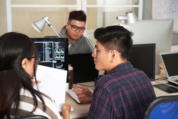 College-Studenten diskutieren Programmiercode im Informatikunterricht, wenn sie gemeinsam an einem Projekt arbeiten