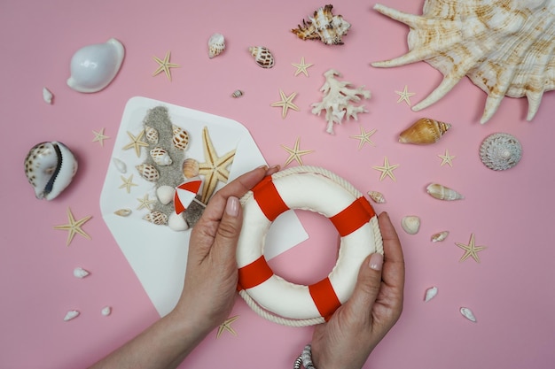 Se coloca un salvavidas sobre un fondo rosa con una estrella de mar.