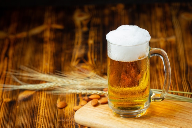 Se coloca un vaso de cerveza en el piso de madera.