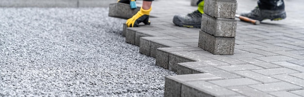 Foto colocación de adoquines entrelazados durante la construcción de pancartas de aceras y carreteras con espacio de copia