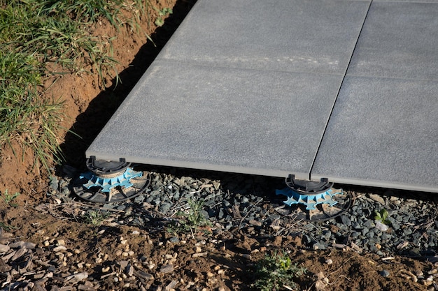 Colocación de losetas de pavimento exterior en la terraza de la casa con parcelas regulables