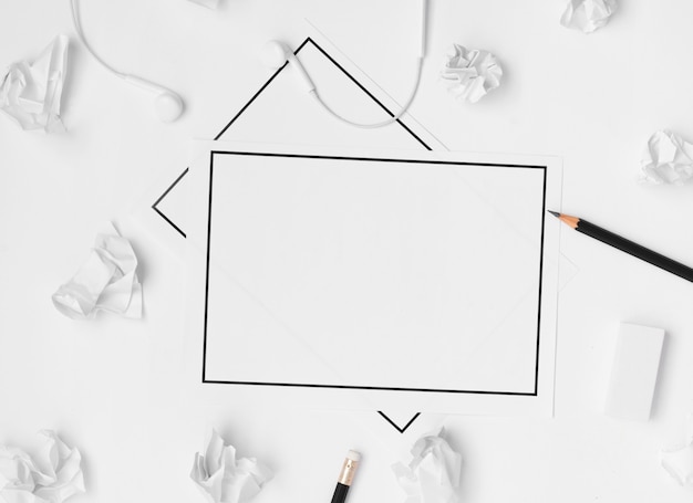 Colocación plana de los accesorios del espacio de trabajo de escritorio con una hoja de papel en blanco sobre fondo blanco