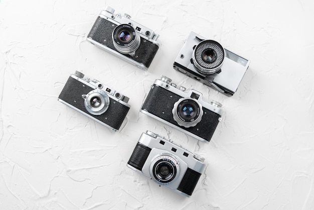Colocación plana de viejas cámaras fotográficas antiguas en el fondo blanco con espacio libre para maquetas de texto