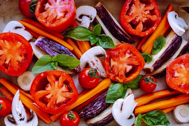 colocados en plano sobre una bandeja para hornear verduras frescas zanahorias, berenjenas, cortadas en cubos