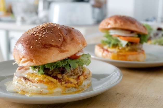 Se colocan dos juegos de hamburguesas en un plato sobre una mesa de cocina de madera.