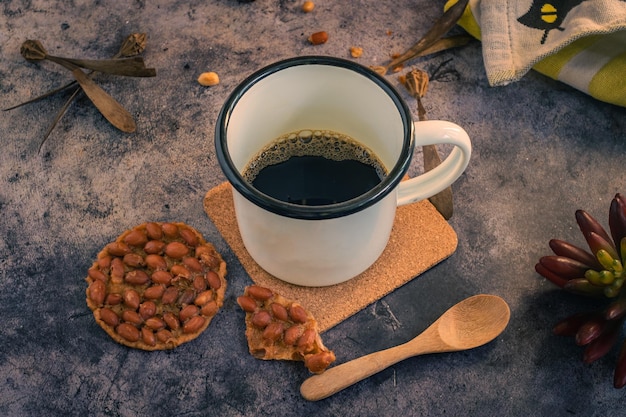 Foto se colocan tazas de café y nueces fritas sobre la mesa.