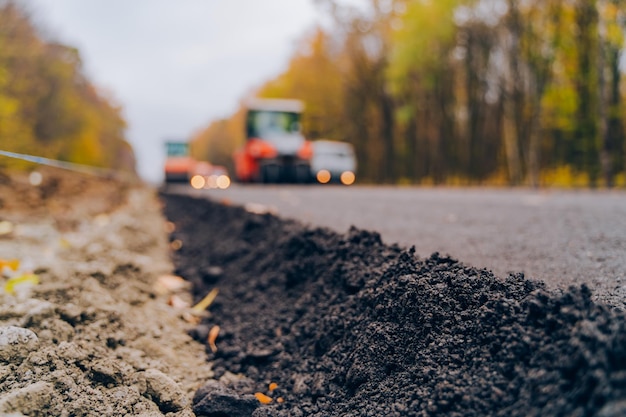 Colocando um novo asfalto na estrada trabalhador operando máquina pavimentadora de asfalto durante a construção da estrada construção da estrada