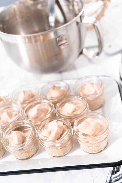 Colocar a mistura em pequenos potes de vidro para fazer sorvete de chocolate caseiro