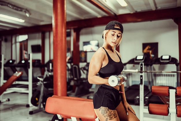 Colocar ejercicio de niña con mancuernas en el gimnasio.