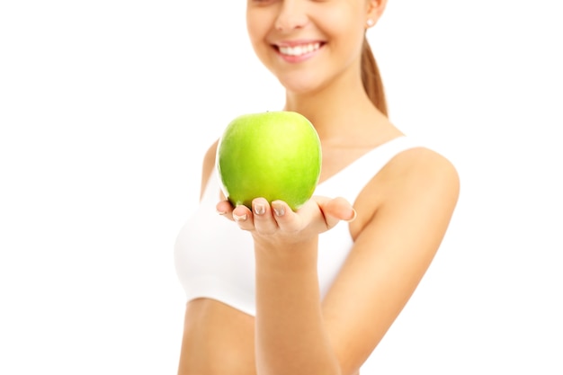 Colocar feliz mujer dando manzana verde sobre fondo blanco.