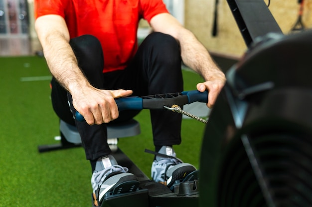 Colocar hombre formación en máquina de remo en el gimnasio