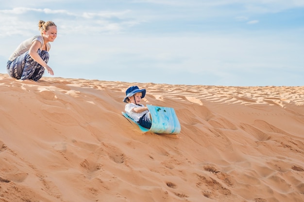 Colocar madre con hijo corriendo en el desierto de Gran Canaria, Maspalomas al atardecer.