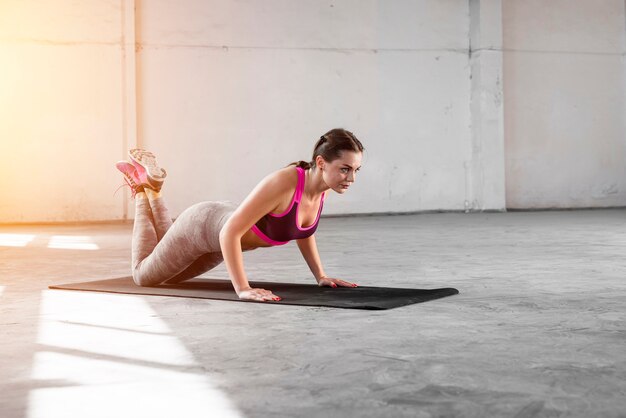 Colocar mujer haciendo ejercicio en la estera de yoga