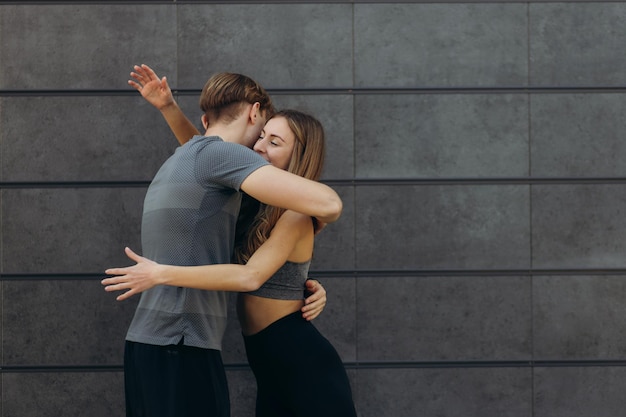 Colocar a una mujer hermosa y un hombre musculoso guapo después de un entrenamiento al aire libre abrazándose y sonriendo Pareja Concepto de estilo de vida deportivo saludable Emociones de personas reales