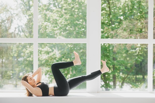 Colocar mujer pose yoga ejercicio en estudio sobre ventana panorámica