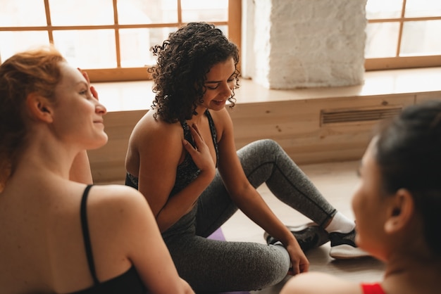 Colocar mujeres atléticas que se relajan después del entrenamiento. Entrenamiento de entrenamiento físico intenso en gimnasio industrial loft.