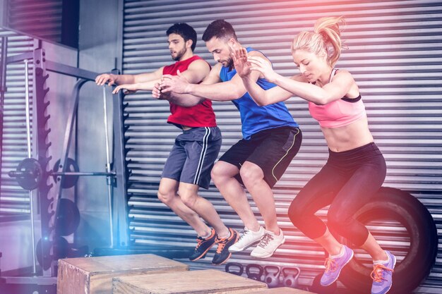 Colocar pessoas fazendo exercícios com caixa no ginásio crossfit