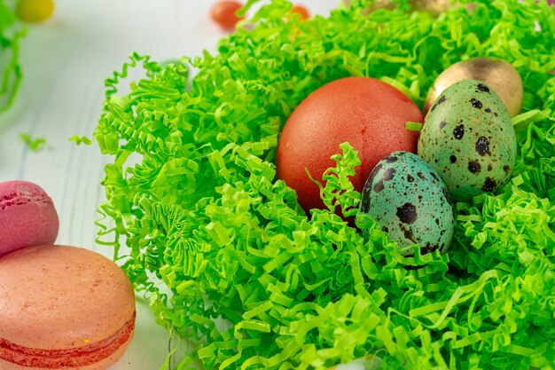 Colofrul Ostereier und verstreute Bonbons auf Holztisch