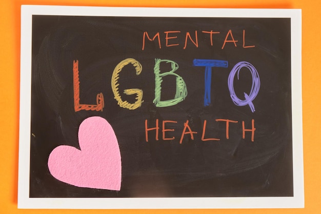 Foto coloful inscripción salud mental lgbtq en concepto de orgullo de fondo naranja pizarra negra