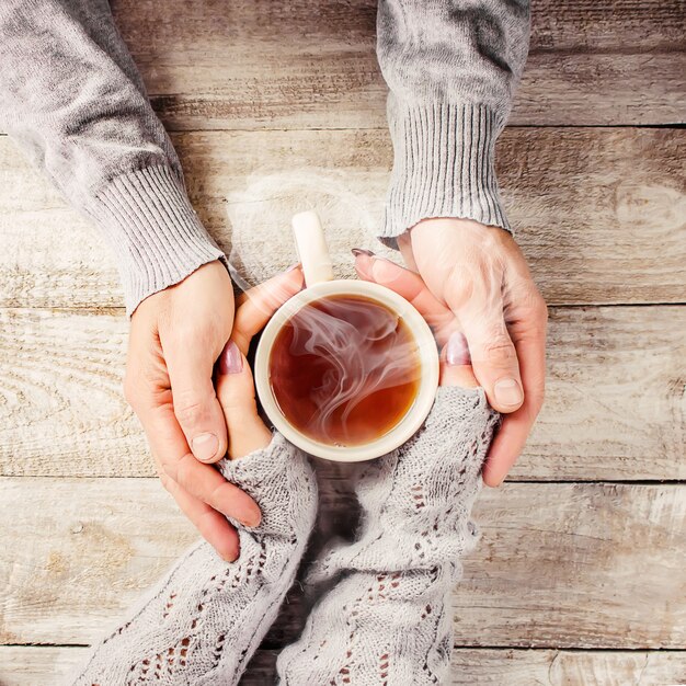 Coloque a bebida para o café da manhã nas mãos dos amantes. Foco seletivo.