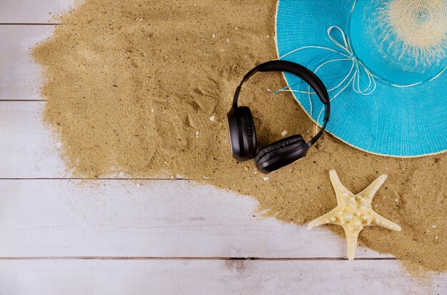 Coloque accesorios planos de playa para vacaciones con sombrero de playa de verano, zapatillas de playa, auriculares