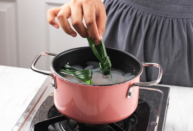 Coloque la hoja de pandan en una sartén rosa que contenga fruta de palma de azúcar (Kolang Kaling). Proceso de cocción Elaboración de Manisan Cangkaleng para Ramadán desayunando Takjil