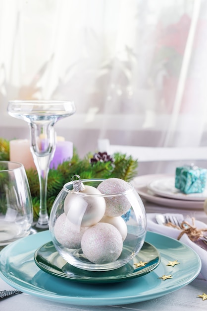 Coloque la mesa para la mesa blanca de Navidad con elementos decorativos azules y plateados con ramas verdes Árbol de Navidad