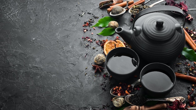 Coloque el té chino tradicional sobre fondo de piedra negra Té en tetera y taza Vista superior espacio libre para su texto