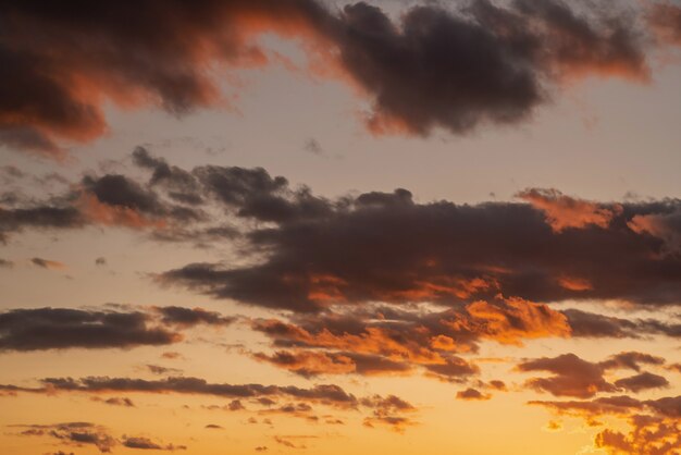 Color amarillo anaranjado púrpura del cielo nublado cuando la hora del atardecer