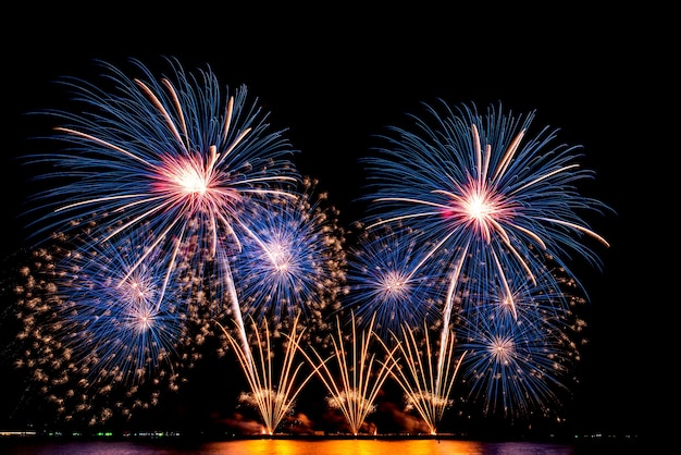 El color y la belleza de los fuegos artificiales instalados en el mar, en el cielo negro por la noche, para celebrar el festival navideño, a la gente y al concepto de Feliz Año Nuevo.