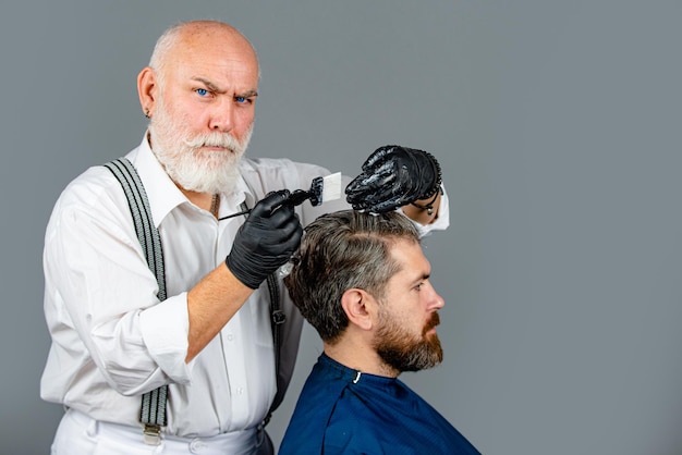 Color de cabello para chico hipster. Proceso de un hombre con la coloración del cabello en la peluquería.